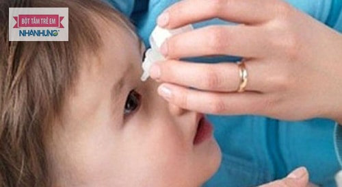 Rửa sạch mắt cho bé bằng dung dịch nước nhỏ mắt.