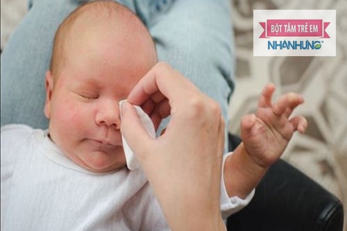 Dùng bông ghèn lau sạch mắt cho con để tránh nhiễm trùng.