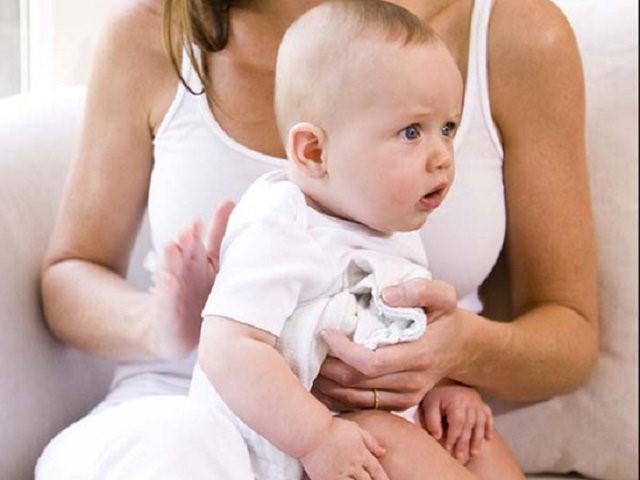 Vỗ nhẹ vào lưng và vai bé để con hết nấc.