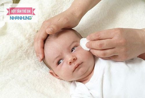 Lau sạch hết các ghèn bám ở mắt cho bé bằng bông gòn.