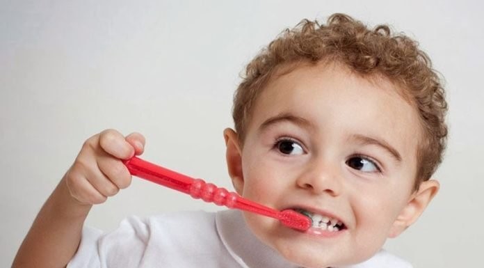 Cho bé đánh răng hàng ngày để hỗ trợ điều trị nhiệt miệng.