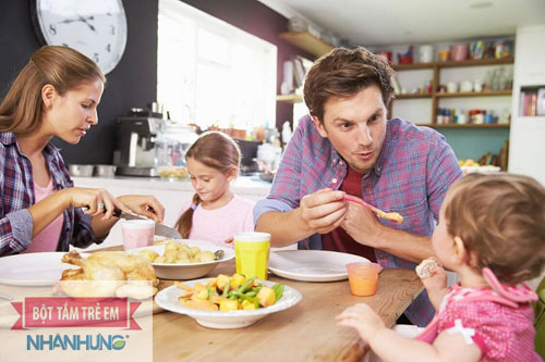 Cho bé ngồi ăn cùng gia đình để bé tự lập ăn uống 